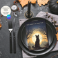 Halloween-themed table setting with a black cat and moon designed invitation on a napkin, surrounded by candles and leaves.