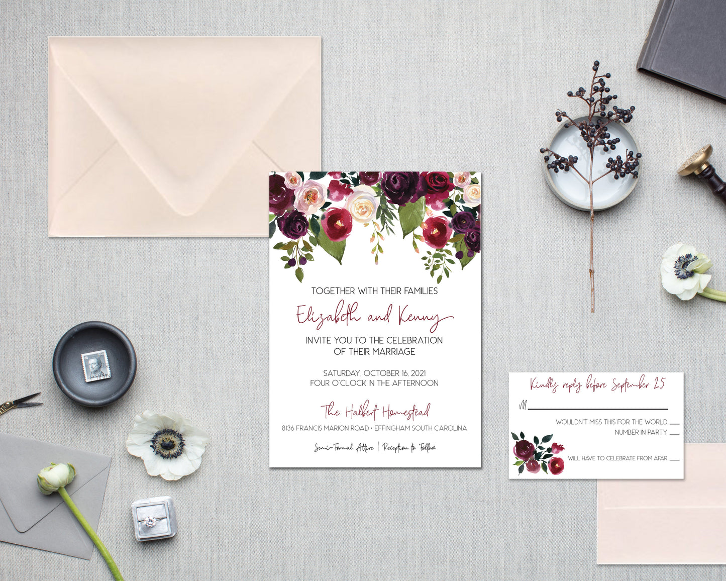 Wedding invitation set with floral design on a gray surface