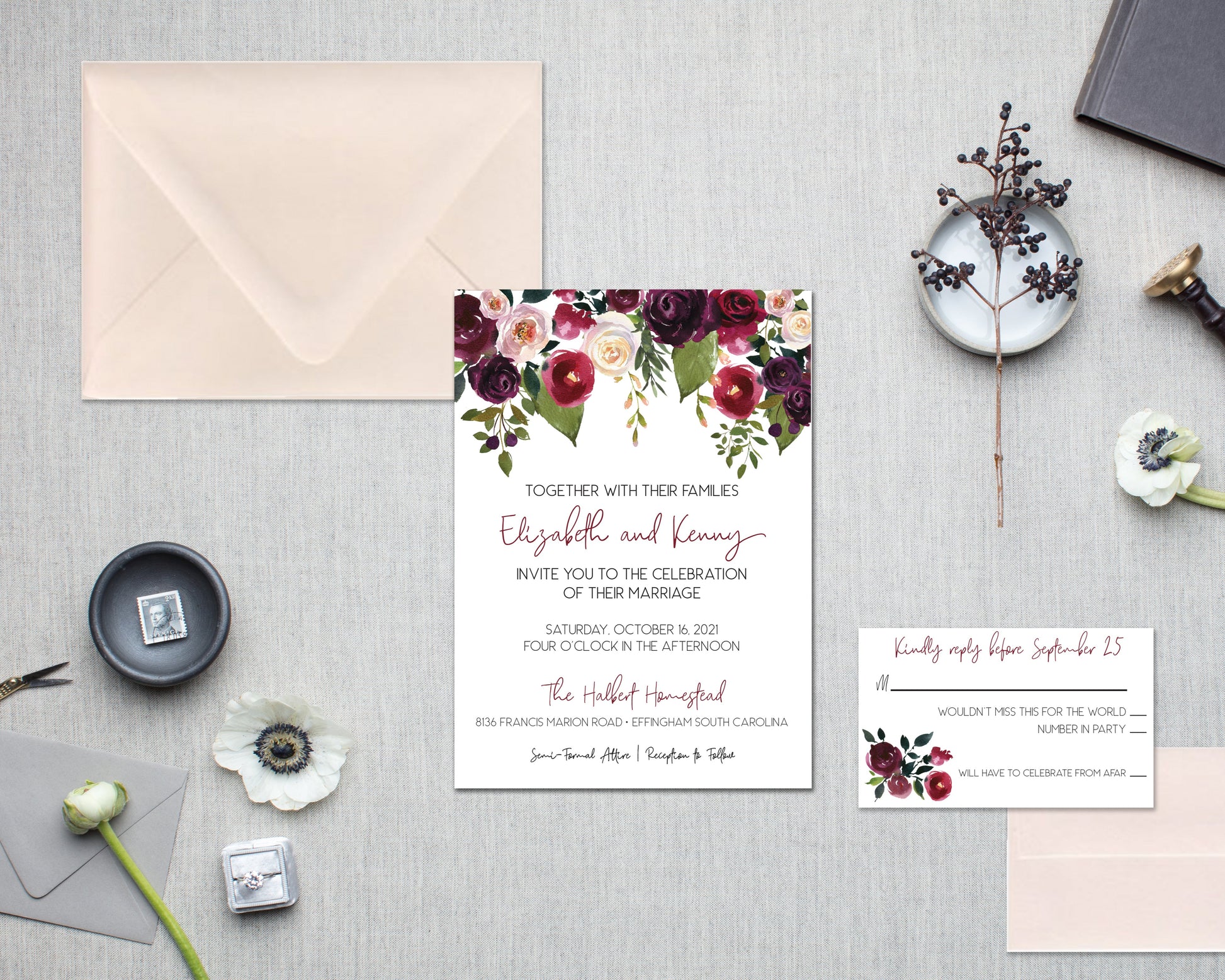 Wedding invitation set with floral design on a gray surface