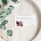 Floral RSVP card on a wooden surface with eucalyptus leaves.