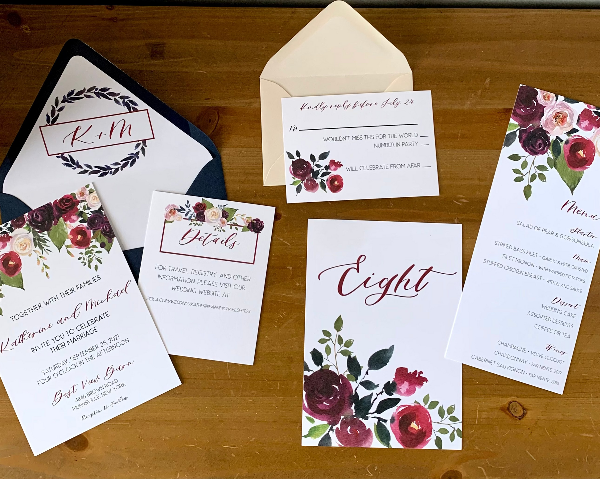 Wedding invitation set with floral designs on a wooden surface