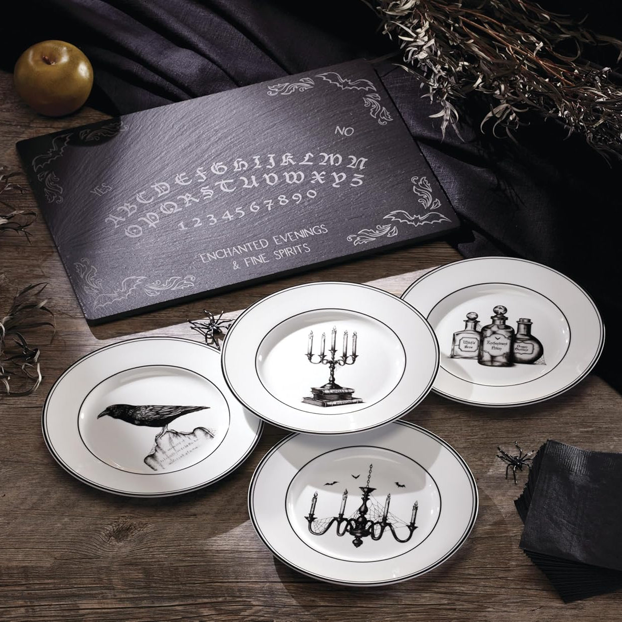 Set of decorative plates with black and white designs on a wooden surface with a dark card featuring an alphabet and numbers.