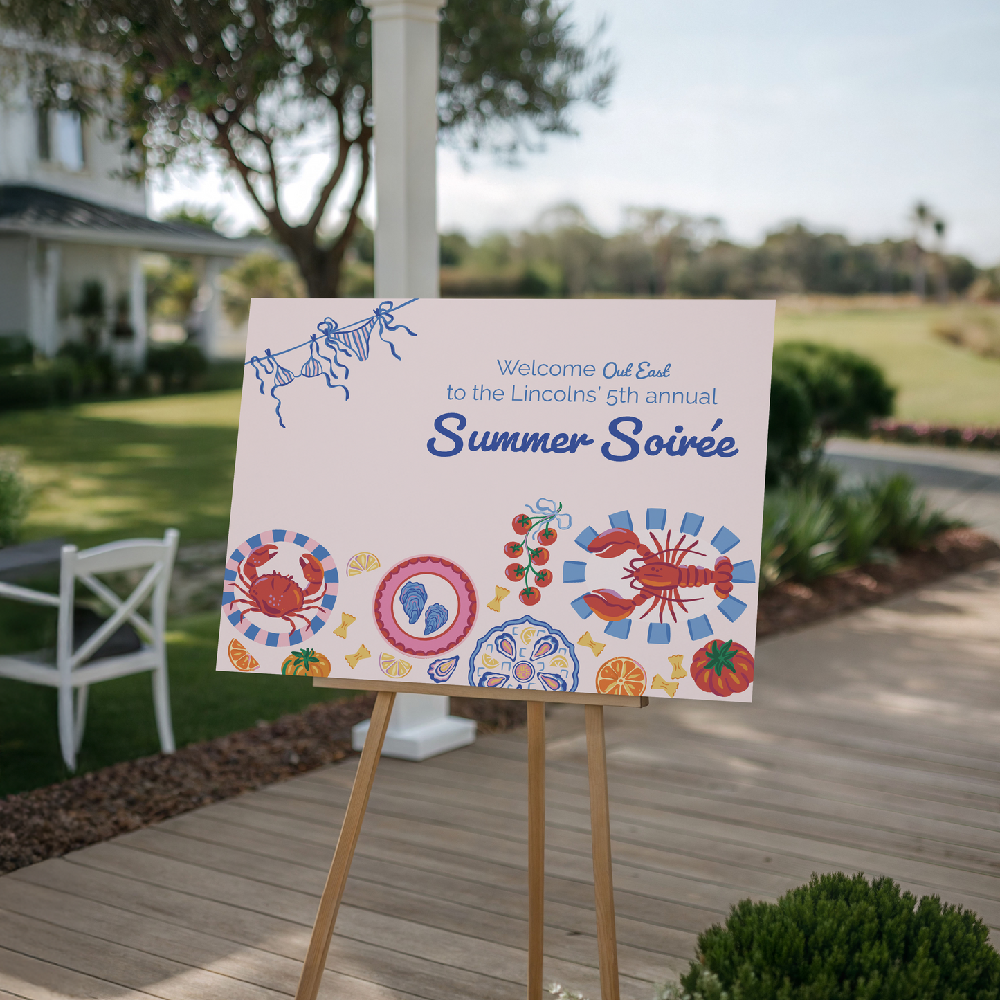 Colorful sign for a 'Summer Soiree' event on a wooden deck with outdoor setting.