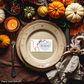 Decorative table setting with pumpkins, candles, and a place card for 'Robert'.