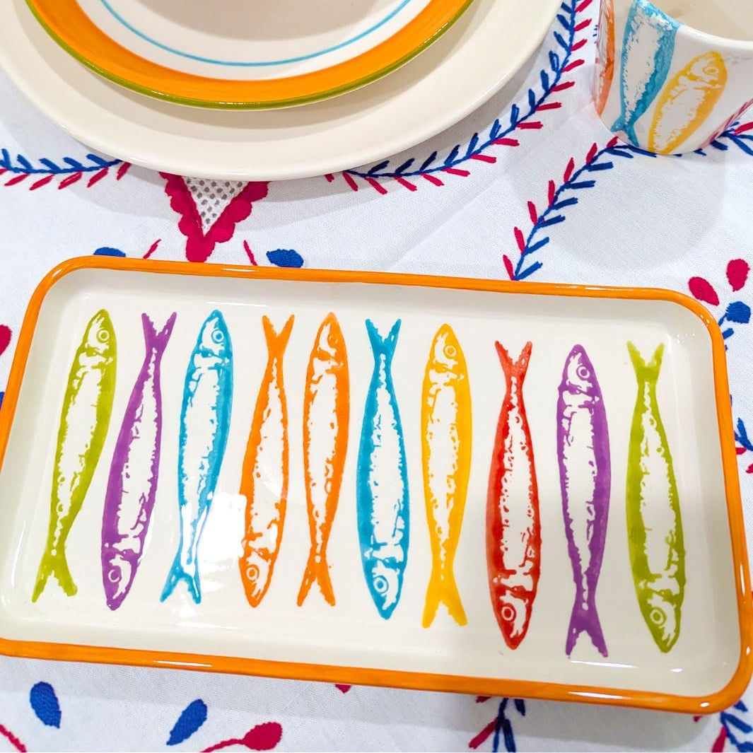 Colorful ceramic plates with fish designs on a patterned tablecloth
