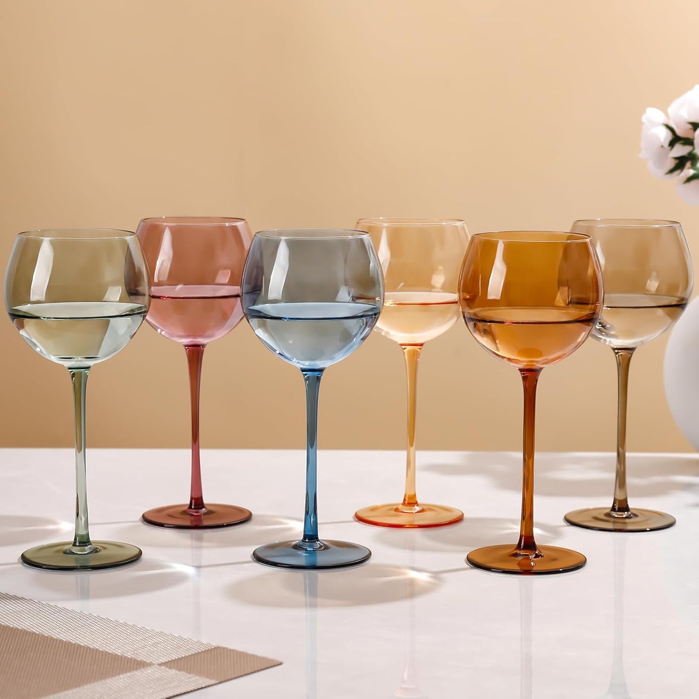 Set of colorful wine glasses on a light surface with a beige background